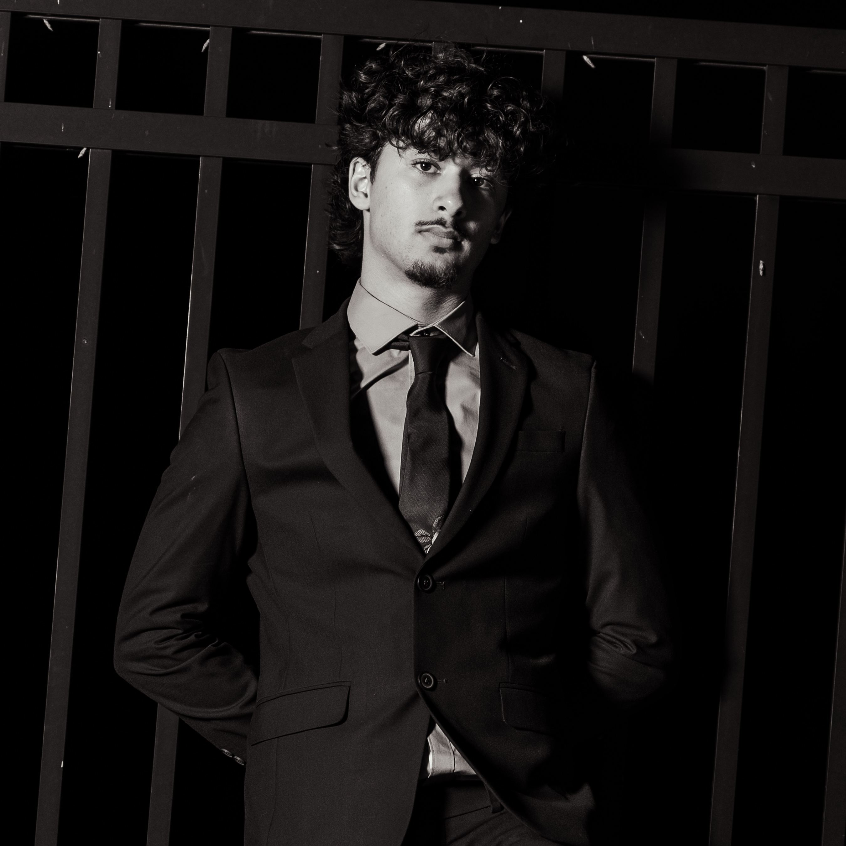 Editorial portrait in a tailored suit at a gate