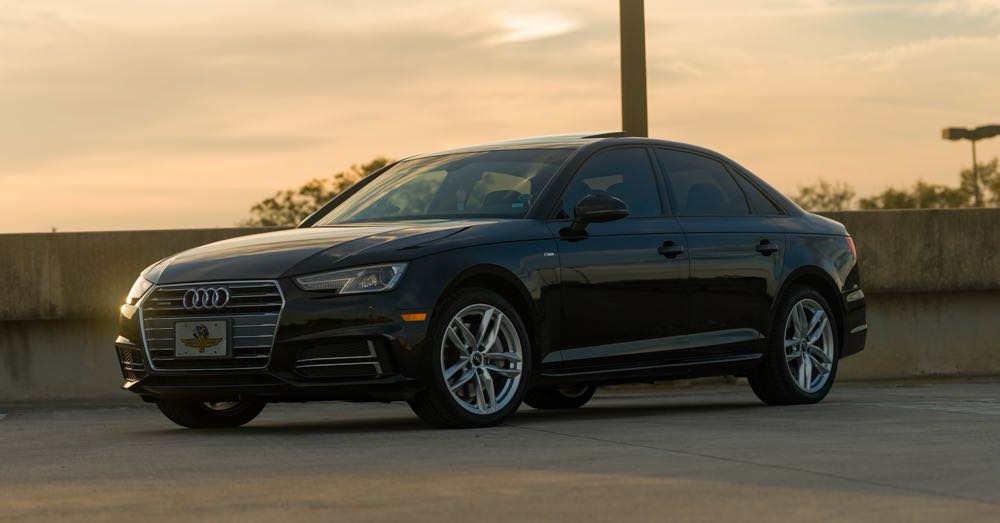 Black Audi sedan at sunset on a Florida overpass
