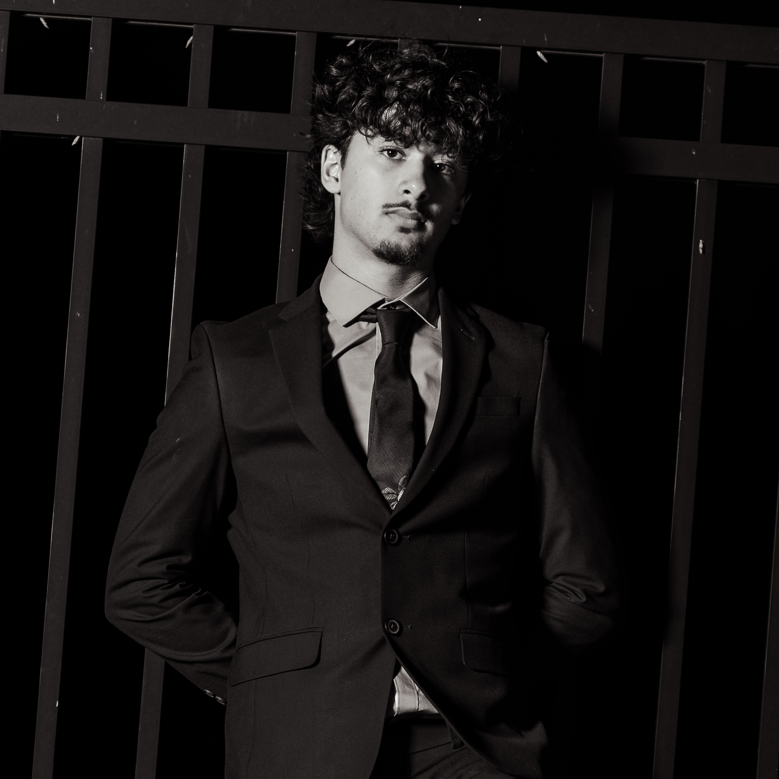 Editorial portrait in a tailored suit at a gate